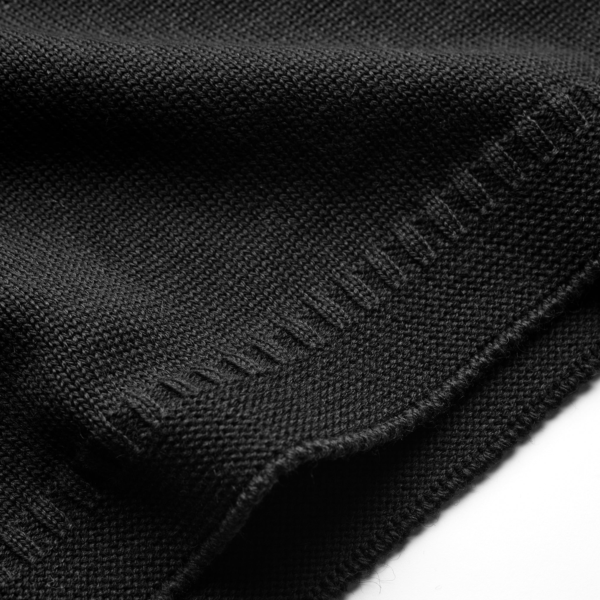 Ribbed hem detail on the Guernsey Woollens x Fox roll neck knit in Midnight Black